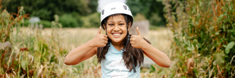Thumbs up as girl completes the challenge course at Woodrow High House