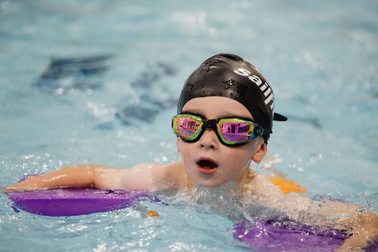 Boy swimming in pool with goggle and floats at Woodrow Leisure Centre