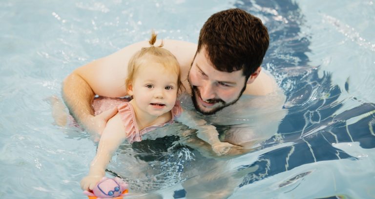 Parent and child swim together at swimming lesson at Woodrow Leisure Centre